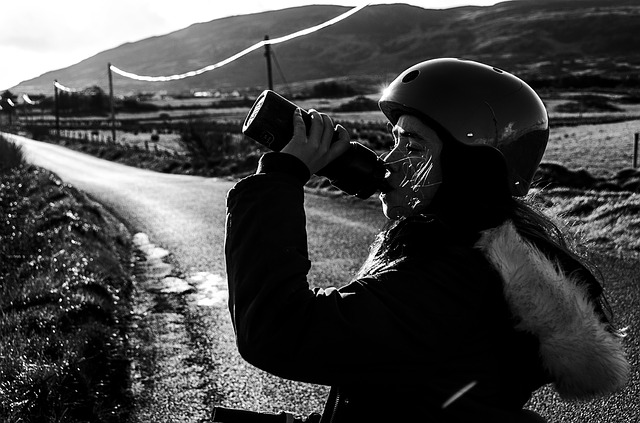 černobílá fotka – detail hlavy cyklisty, který pije